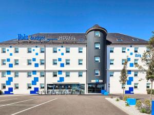 a hotel with a parking lot in front of it at ibis budget La Roche Sur Yon Vendespace in Mouilleron-le-Captif