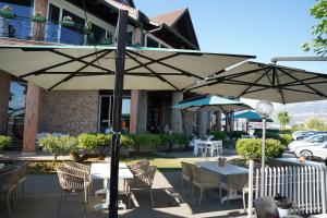 an outdoor patio with tables and chairs and umbrellas at Resort Nord Park in Fushë-Krujë