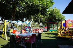a table and chairs in a park with a playground at Resort Nord Park in Fushë-Krujë