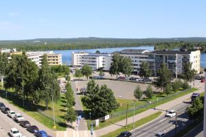 an apartment complex with a parking lot and a lake at Lapland Apartment in Rovaniemi