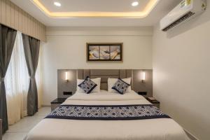 a bedroom with a large bed with blue and white pillows at Hotel Lavish Regency in Ahmedabad