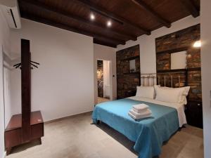 a bedroom with a bed with a blue blanket at Nykteri Heritage House Olympus & Sea View in Palaios Panteleimonas