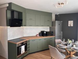 a kitchen with green cabinets and a dining table at Casmere Suite in Pomorie +20 photos