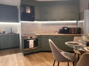 a kitchen with a table and some chairs and a counter at Casmere Suite in Pomorie