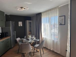 a dining room with a table and chairs and a window at Casmere Suite in Pomorie