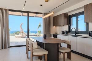 a kitchen with a table and chairs and a large window at Nysa Luxury villas 3-4-5-6 in Heraklion