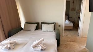 a bed in a room with two towels on it at Olea Village in Potos +50 photos
