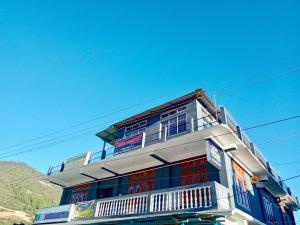 a blue and white building with a balcony at Tenzin Homestay in Dirang Dzong