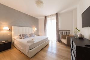 una camera con un letto bianco e una finestra di Design & Luxury Apartment Verona a Verona