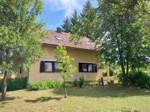 a house with two windows in a yard with trees at Studioapartment Taiga in Grabovac