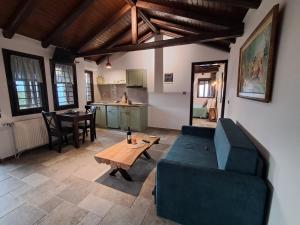 a living room with a couch and a table at Nykteri Heritage House Olympus & Sea View in Palaios Panteleimonas