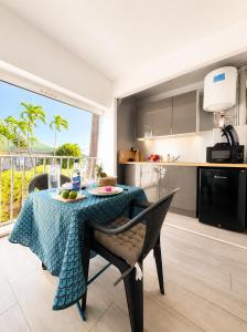 a kitchen with a table with a table cloth on it at Reflet Marin - Studio Village Soleil in Le Gosier