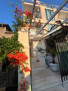 a stairway with red flowers in front of a building at Hotel NEMO in Kiten