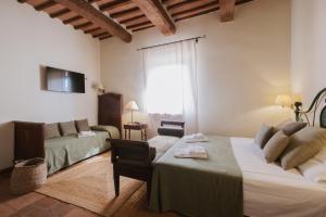 a hotel room with a bed and a couch at Hotel Relais Santa Genoveffa in Paganico