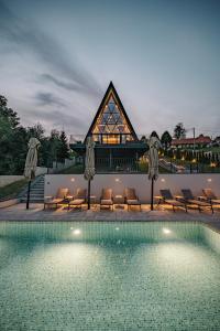 a swimming pool with chairs and a building at The Frame Croatia in Ravna Gora