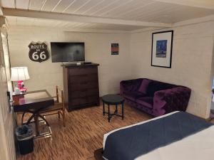 a bedroom with a bed and a purple couch at Sterling Gardens in Las Vegas