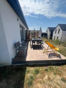a patio with a table and chairs on it at Les Cortalines Equihen in Équihen-Plage