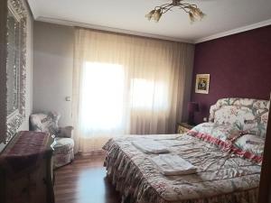 a bedroom with a bed and a couch and a window at Fuenteazul in Hortigüela +16 photos
