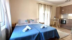 a bedroom with a blue bed with towels on it at MoSta Sunset in Litochoro
