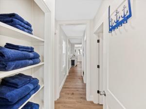 a hallway with blue towels on shelves at Modern Coastal Cottage Near Destin & Beaches in Niceville +41 photos
