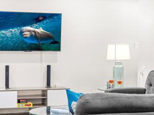 a living room with a dolphin on the tv screen at Modern Coastal Cottage Near Destin & Beaches in Niceville