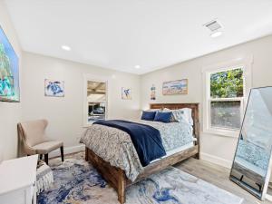 a bedroom with a bed and a desk and windows at Modern Coastal Cottage Near Destin & Beaches in Niceville