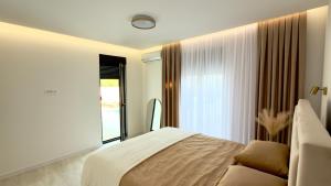 a bedroom with a bed and a large window at Villa Maja in Blagaj