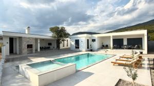 a house with a swimming pool and a patio at Villa Maja in Blagaj