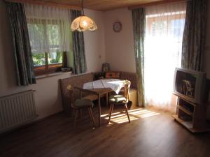 sala de estar con mesa, sillas y TV en Appartement Grubbauer, en Wagrain