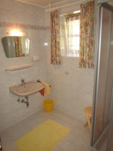 uma casa de banho com um lavatório e um espelho em Appartement Grubbauer em Wagrain