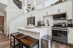 a kitchen with white cabinets and a counter with stools at Quarry A35 in Whitefish +42 photos
