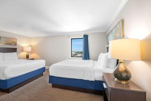 a hotel room with two beds and a window at Bask Hotel at Big Rock Landing in Morehead City