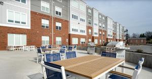a patio with a table and chairs and a building at Parkview Greer 2BR Retreat in Greer