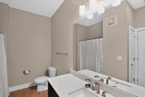 a white bathroom with a sink and a toilet at Parkview Greer 2BR Retreat in Greer +13 photos