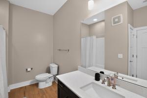 a white bathroom with a sink and a toilet at Parkview Greer 2BR Getaway in Greer +13 photos