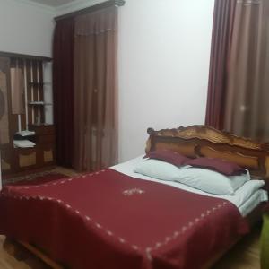 a bedroom with a bed with a red comforter at Noy in Goris