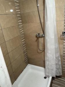 a bathroom with a shower with a white shower curtain at Katun Lanista-Kolibe Bogavac in Mojkovac
