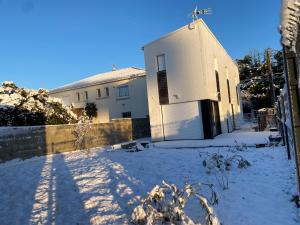 a white building with snow on the ground at La Maison Blanche 1 in Bouguenais