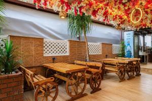a restaurant with wooden tables and chairs and flowers at Dublin Hotel in Alanya