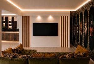a living room with a couch and a flat screen tv at Alpine Residence by alpenappartements in Mayrhofen