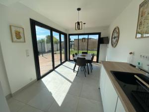 a kitchen and dining room with a table and chairs at La Maison Blanche 1 in Bouguenais
