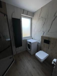 a bathroom with a toilet and a window at Apartament Żurawie in Jastrowie