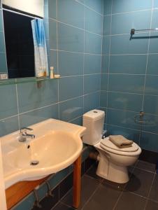 a bathroom with a toilet and a sink at Lily's Studios in Nikiana