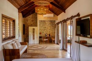 a living room with a couch and a tv at Villa Alegria - La Villa Group in Jericoacoara
