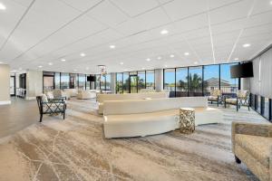 a lobby with couches and tables and windows at Bask Hotel at Big Rock Landing in Morehead City