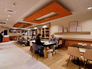 people sitting at tables in a restaurant at ibis budget Cholet Centre in Cholet