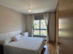 a small bedroom with a bed and a window at Petit con piscina in Pontevedra +15 photos
