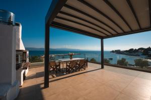 a patio with a table and a view of the water at Filippos Apartments in Amarynthos