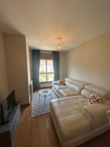 a living room with a couch and a tv at Petit con piscina in Pontevedra