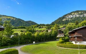 a winding road through a village with a mountain at Studio à Praz-sur-Arly in Praz-sur-Arly